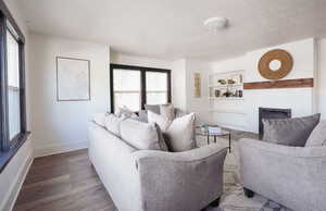 Living room featuring a healthy amount of sunlight, built in features, and wood-type flooring