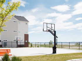 View of sport court with a yard and a water view