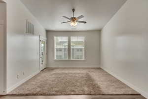 Carpeted empty room featuring ceiling fan