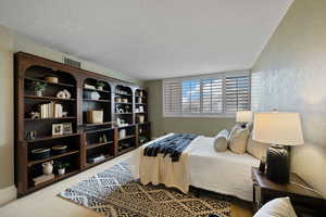 Bedroom with carpet floors and a textured ceiling