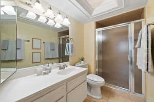 Bathroom with walk in shower, tile patterned floors, crown molding, toilet, and vanity