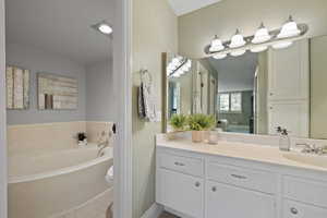 Bathroom featuring tile patterned floors, a bathing tub, vanity, and toilet