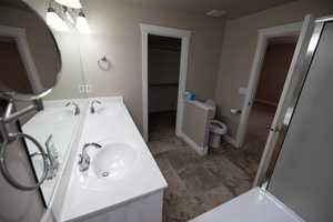 Bathroom featuring toilet, vanity, and a notable chandelier