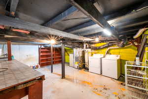 Basement featuring heating unit, washer and clothes dryer, and gas water heater