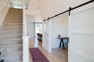 Staircase featuring wood banister & 2 story entry