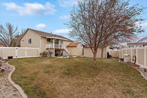 Back of property with a storage shed, a yard, and a wooden deck