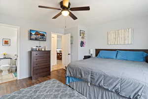 Bedroom with connected bathroom, dark hardwood / wood-style flooring, and ceiling fan