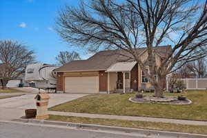 View of front of home featuring a front yard and a garage