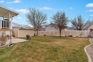 View of yard featuring a patio area, a storage unit, and a mountain view