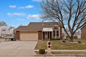 View of front of home with a front yard and a garage