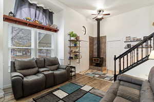 Living room featuring ceiling fan, hardwood / wood-style floors, and a wood stove