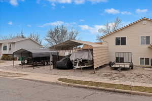 View of parking / parking lot featuring a carport