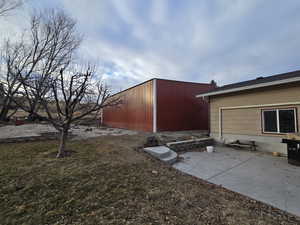 View of yard with an outbuilding and a patio