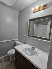 Bathroom featuring a textured ceiling, tile patterned floors, vanity, and toilet