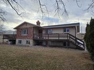 Rear view of house with a deck and a yard