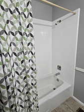 Bathroom featuring tile patterned floors and shower / bathtub combination with curtain