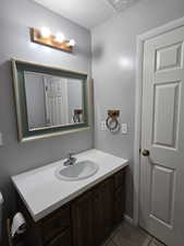 Bathroom with a textured ceiling, vanity, and tile patterned floors