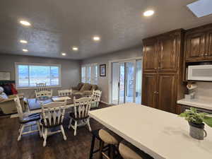 Dining area with a textured ceiling and dark hardwood / wood-style floors