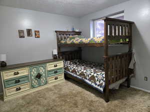 Carpeted bedroom with a textured ceiling