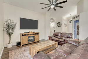 Living room featuring wood-type flooring, ceiling fan, and vaulted ceiling