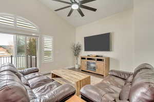 Living room featuring high vaulted ceiling, ceiling fan, and light hardwood / wood-style floors