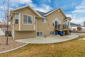 Back of property with a yard, a deck, and a patio area