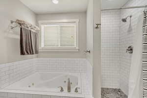 Bathroom featuring separate shower and jetted tub