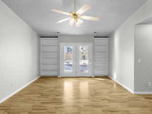 Unfurnished room featuring a textured ceiling, ceiling fan, and light hardwood / wood-style floors