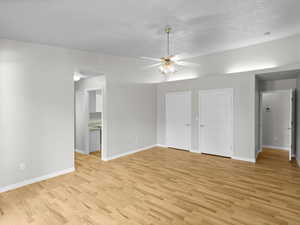 Unfurnished room featuring a textured ceiling, ceiling fan, and light hardwood / wood-style flooring