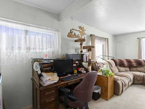 Office area with light carpet and beamed ceiling