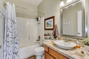 Full bathroom featuring shower / tub combo, vanity, and toilet