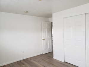 Unfurnished bedroom featuring a closet and hardwood / wood-style flooring