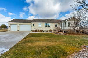 Rear view of house with a lawn, a garage, and a wooden deck