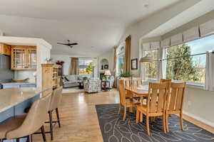 Dining space featuring lofted ceiling, ceiling fan, and light hardwood / wood-style flooring