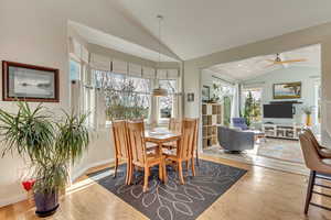 Dining room with ceiling fan, hardwood / wood-style floors, and vaulted ceiling