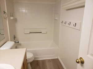 Full bathroom with shower / bathing tub combination, toilet, vanity, and hardwood / wood-style flooring