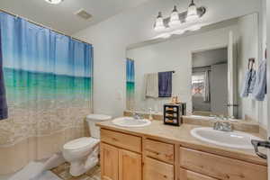 Bathroom featuring tile patterned flooring, vanity, and toilet