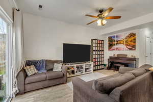 Living room featuring ceiling fan and light hardwood / wood-style flooring