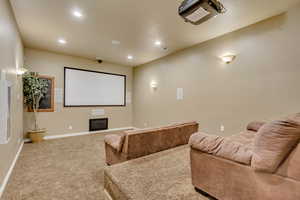 Carpeted home theater with a fireplace