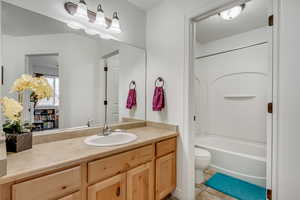 Full bathroom featuring toilet,  shower combination, tile patterned floors, and vanity