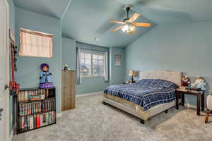 Bedroom featuring vaulted ceiling, ceiling fan, and carpet