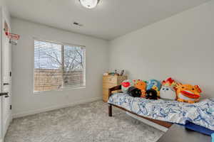 Bedroom featuring light carpet