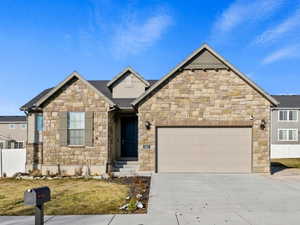 View of front of property with a garage and a front lawn