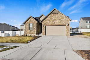 View of front of house featuring a front yard and a garage