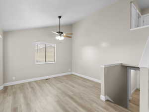 Family/Living room combo with lofted ceiling and light wood-style floors