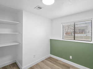 Bedroom with a textured ceiling and  wood-style floors