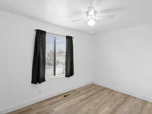 Bedroom with ceiling fan and light wood-style flooring