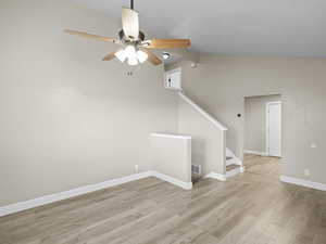 Family/living room with wood-style floors, ceiling fan, and vaulted ceiling