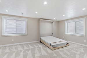 Murphy bed down. Super Nice. Custom made. Unfurnished bedroom with a textured ceiling and light carpet