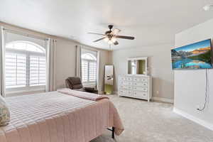 Carpeted bedroom featuring ceiling fan, TV mount stays.  Great south facing windows light!